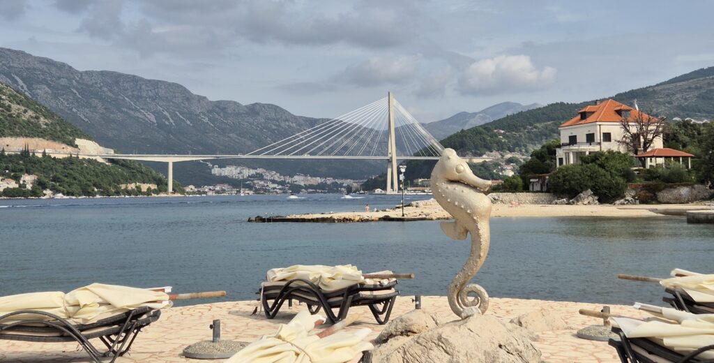 Copacabana Beach in Dubrovnik with crystal-clear waters and stunning views of the Croatian mountains in the distance, ideal for swimming and relaxation.