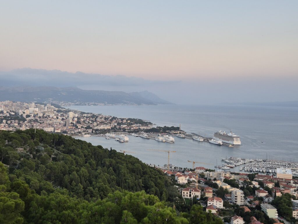 Panoramic view of Split from Marjan Hill, featuring the city’s terracotta rooftops, the Adriatic Sea, and nearby islands under a clear blue sky.