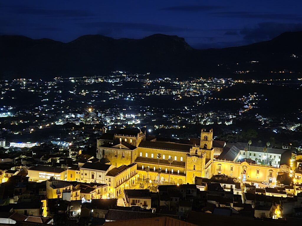 Monreale Cathedral Panorama at night: A wide-angle shot of the Monreale Cathedral from the outside, overlooking the surrounding townscape, with the majestic structure standing as a testament to Sicily’s architectural grandeur.